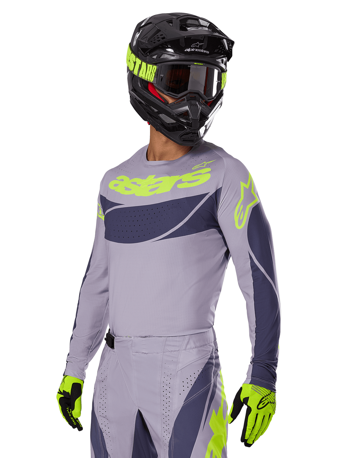 Motocross rider wearing the Alpinestars 2025 Techstar Dreem Jersey in Gray and Dark Gray, featuring a neon yellow 'astars' logo on the chest, paired with a matching helmet, goggles, and gloves for a coordinated off-road racing look