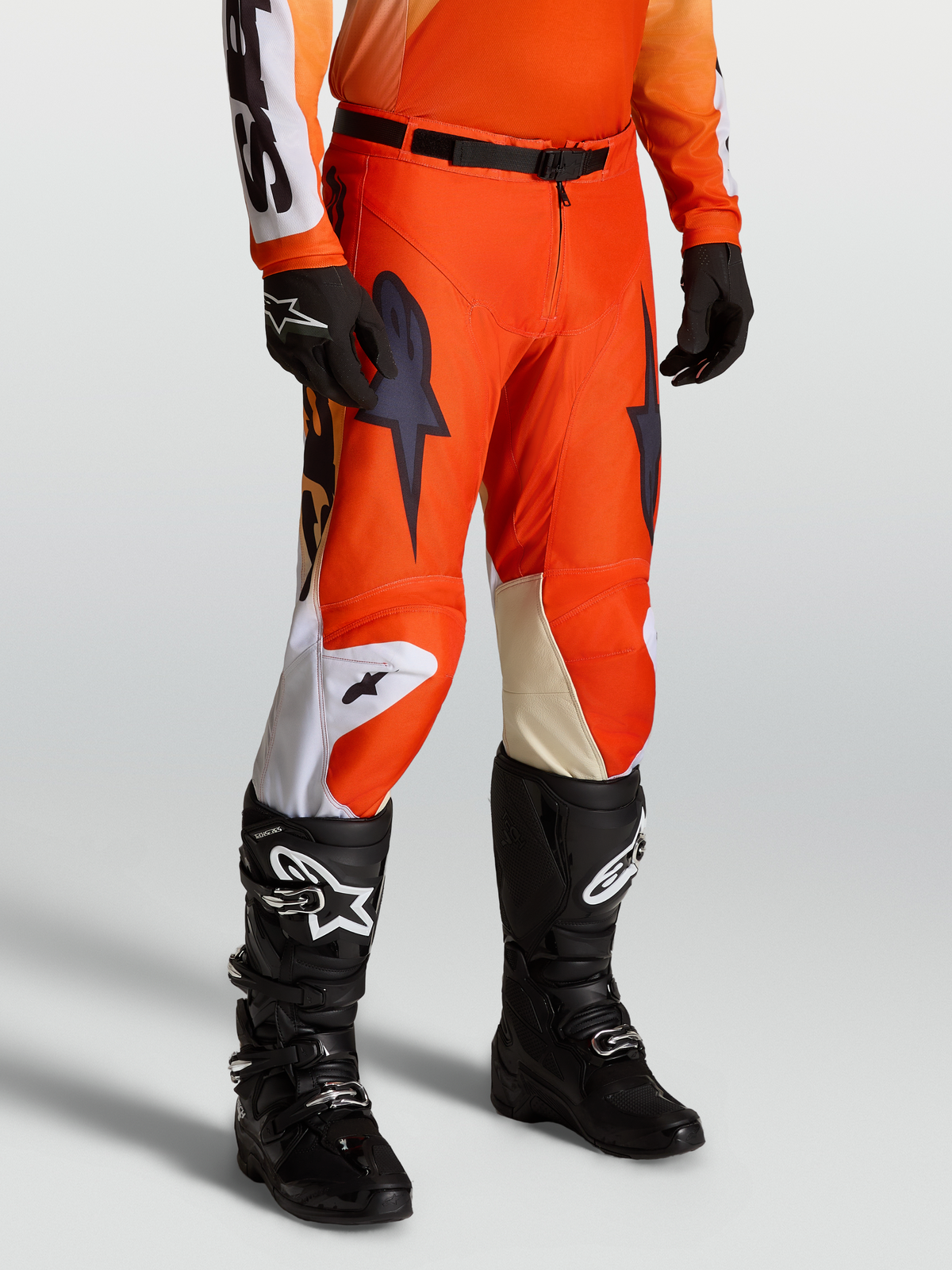 Alpinestars Racer Amber Pants, Men's Motocross Pants in Cardinal Red and Black, featuring a lightweight 600D polyfabric race fit on-model with matching racing jersey, gloves, and Tech Series boots.