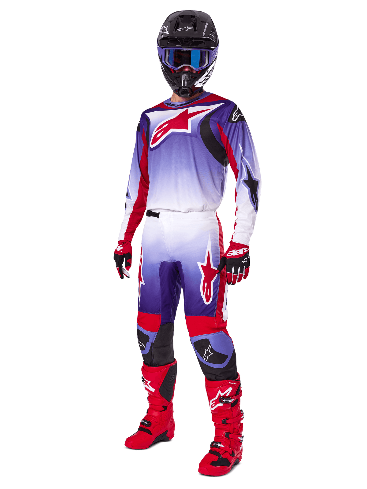 Motocross rider wearing the Alpinestars 2025 Fluid Wurx Gear Set, purple and bright red jersey with white accents, matching motocross pants, bright red boots, black helmet with blue goggles, and red and black gloves, full professional off-road racing kit
