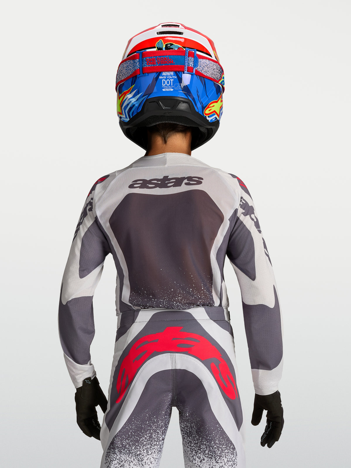 Alpinestars Youth Supertech Swan Motocross Jersey and Pants in gray and white with red fluo accents, back view on-model.