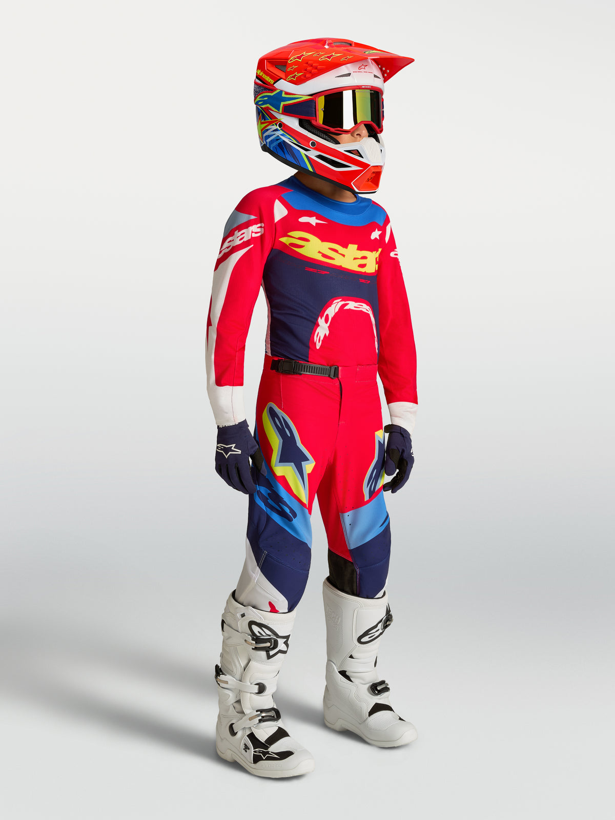 Alpinestars Youth Supertech Dyna Jersey, Fire Red and Navy Blue Motocross Gear Set on a young rider with white boots.