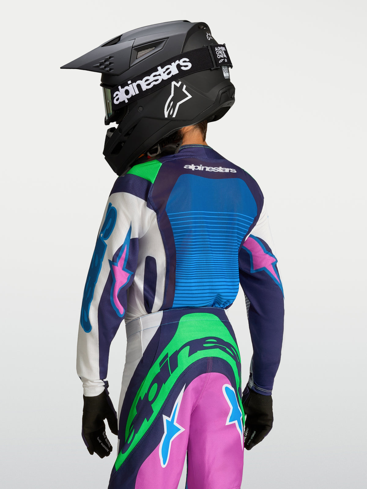 Alpinestars Youth Supertech Maven Jersey, blue and green motocross gear for young riders, rear view wearing a helmet.