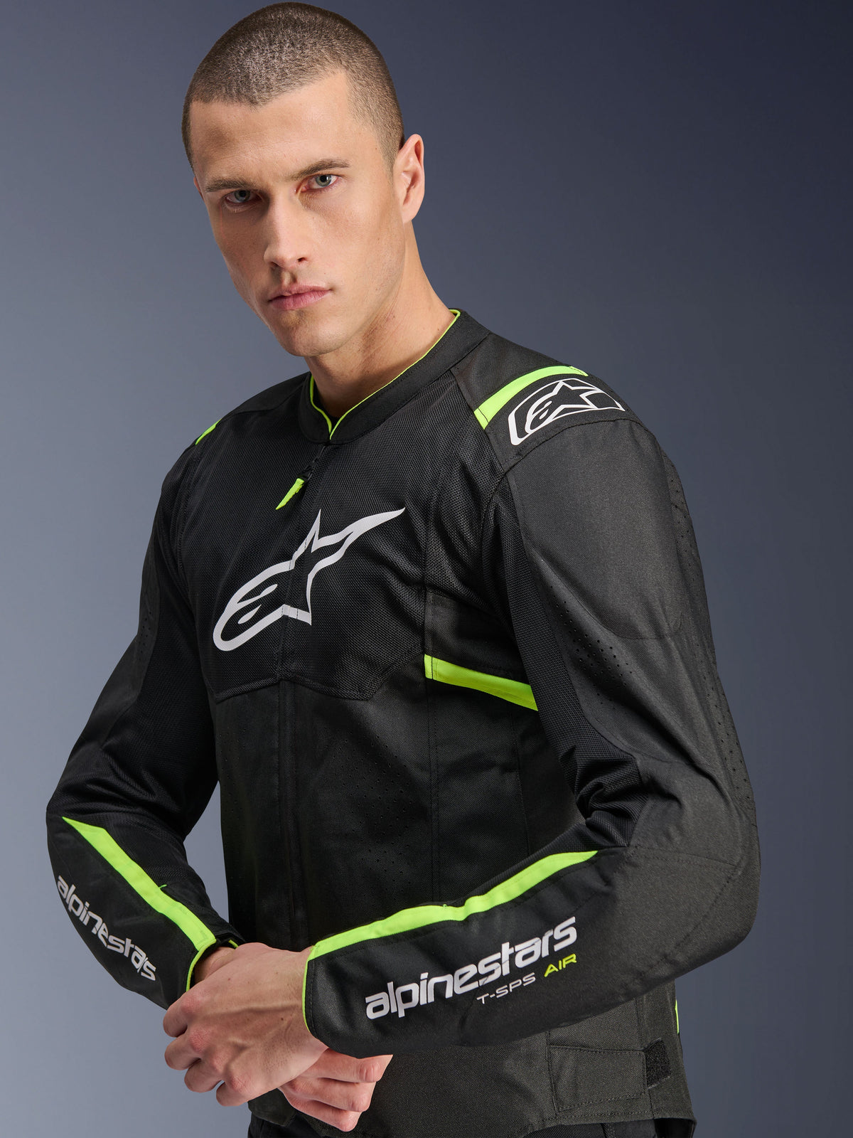 Alpinestars T-Sps Air V2 Jacket, Black Yellow Fluo, textile motorcycle jacket worn by model, featuring tech mesh panels for airflow, white Alpinestars logo on chest, and yellow fluo accents on shoulders and sleeves.