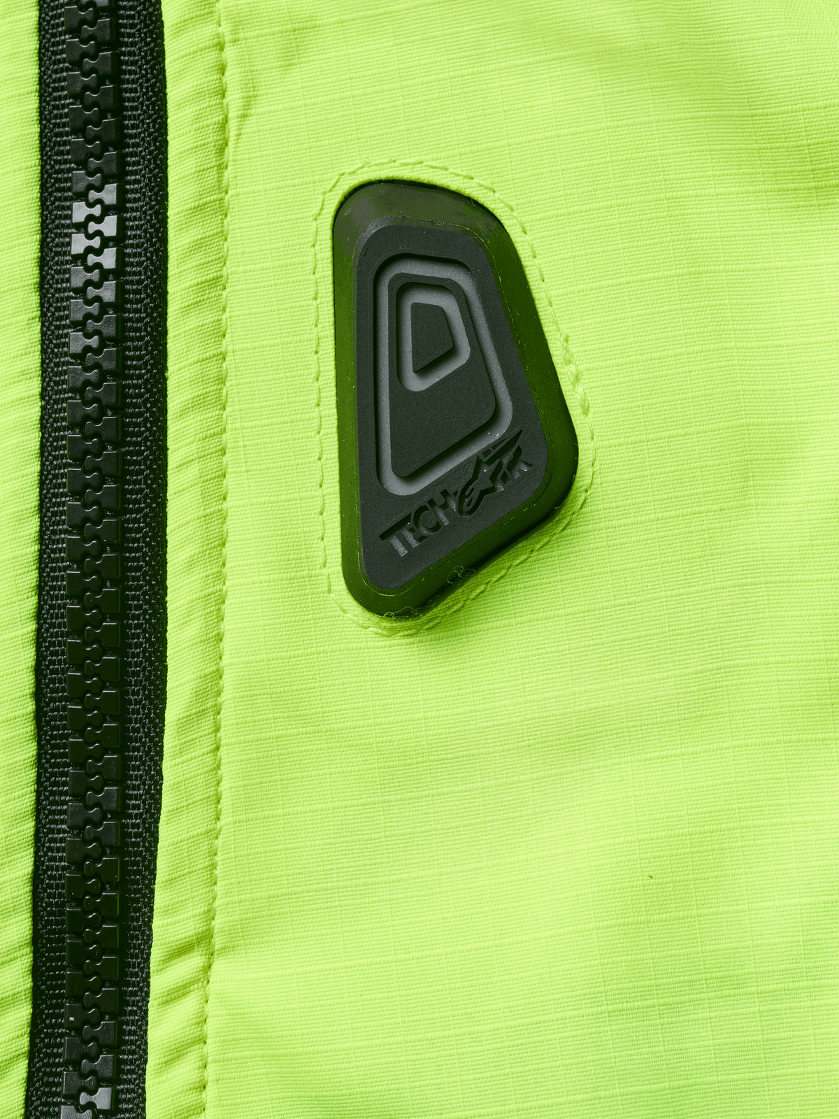 Alpinestars Tech-Air® 3 V2 System, Motorcycle Airbag Vest, Close-up of Yellow Fluo water-resistant fabric with black zipper, featuring a black rubberized Tech-Air logo patch, high-visibility safety gear