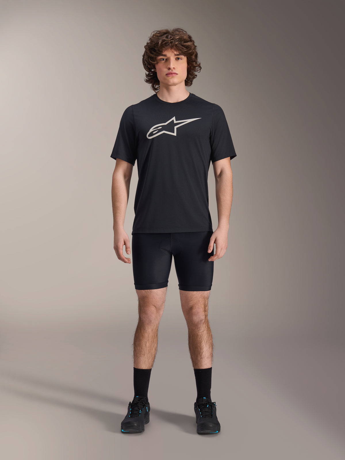 Alpinestars A-Dura Liner Shorts, Black cycling liner shorts, worn by a model with a black Alpinestars logo t-shirt and black cycling shoes, tight-fitting design for MTB performance and in-saddle comfort.