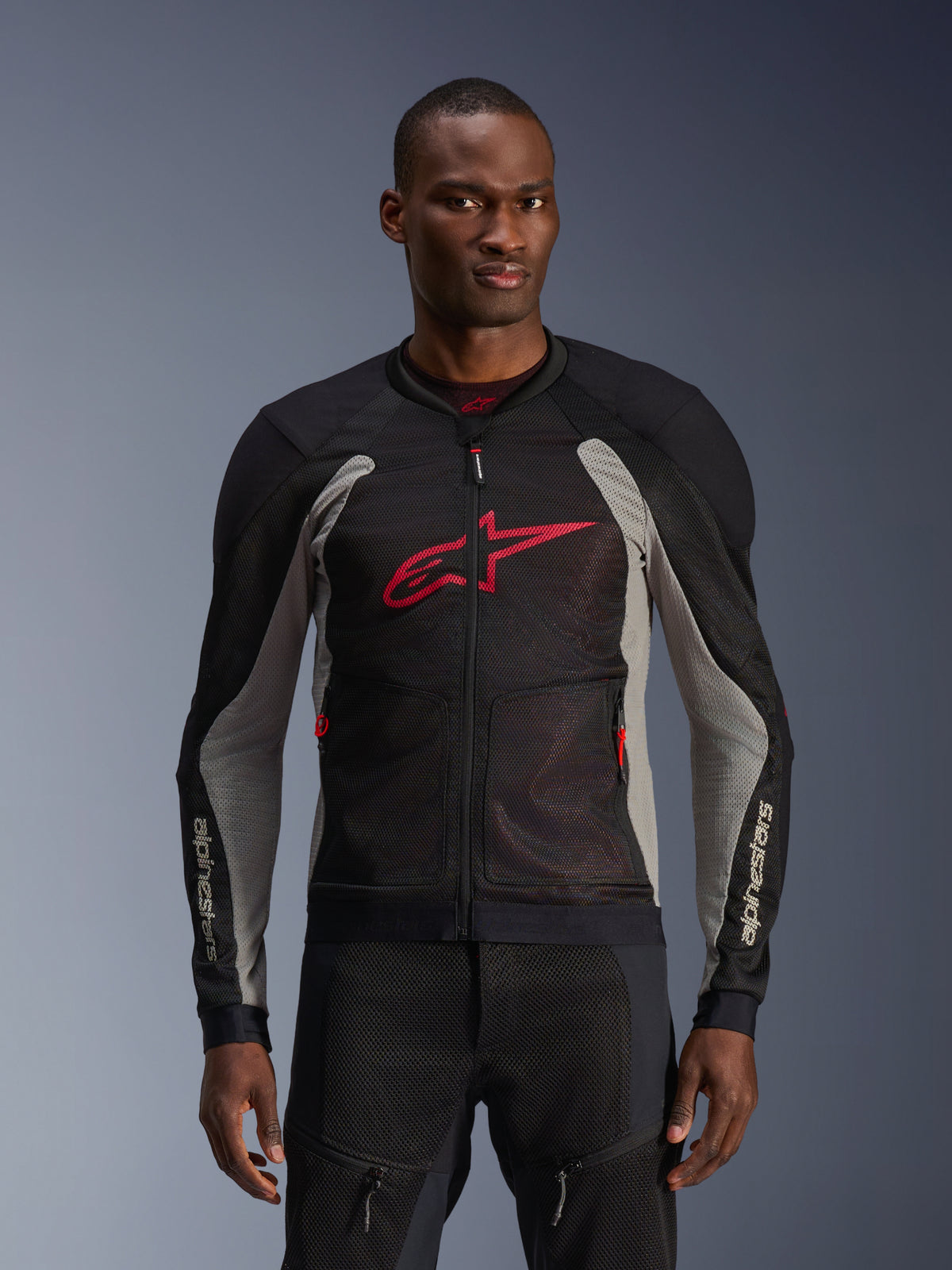 Alpinestars Troop-Air Jacket, Motorcycle Mesh Jacket, Black and Ash Gray with Bright Red accents, worn by a model, featuring breathable 2D tech mesh panels for ventilation, a large red Astars logo on the chest, and a technical sporty design for urban road riding