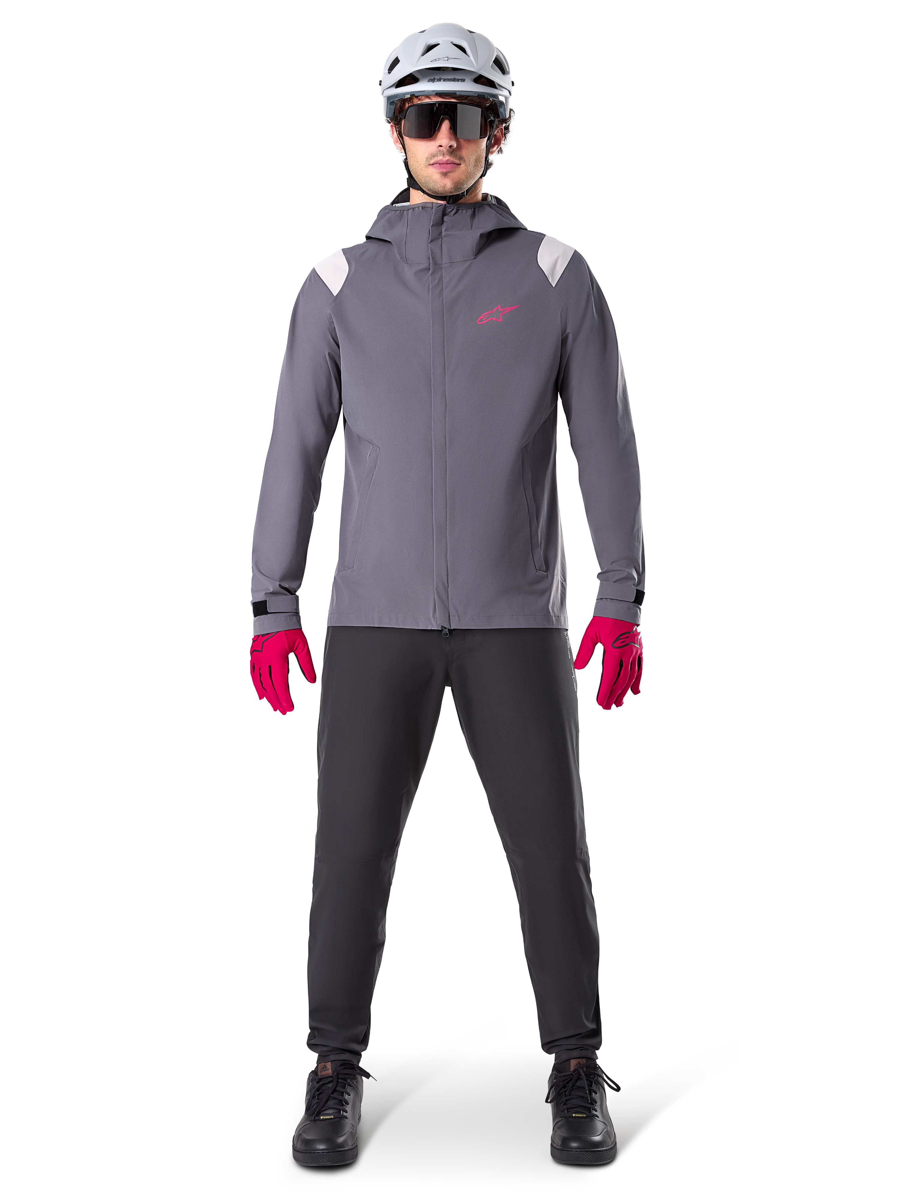 Alpinestars A-Dura Rain Jacket, Mountain Bike Jacket, Dark Titanium Gray with pink logo, worn with grey MTB helmet and bright pink gloves, protective 2.5-layer membrane design for wet weather cycling