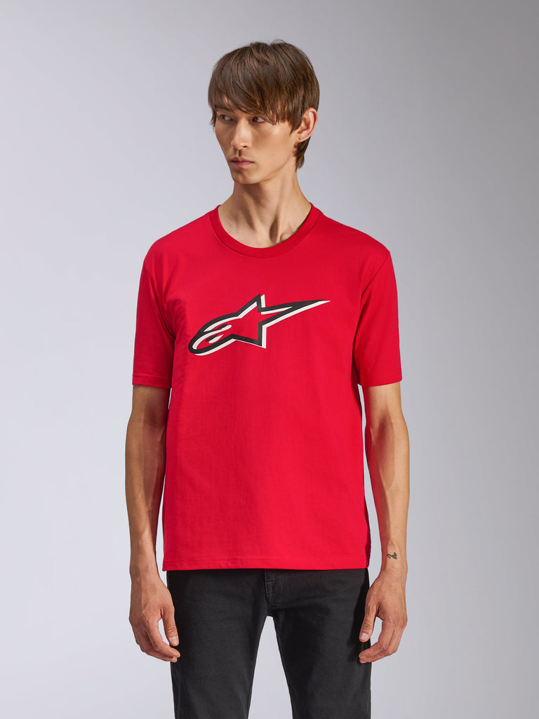 Alpinestars Ageless Shadow CSF Tee, Red Short Sleeve T-Shirt, featuring a front Ageless logo with black and white outlines, worn by a man with black pants, casual motorsport streetwear