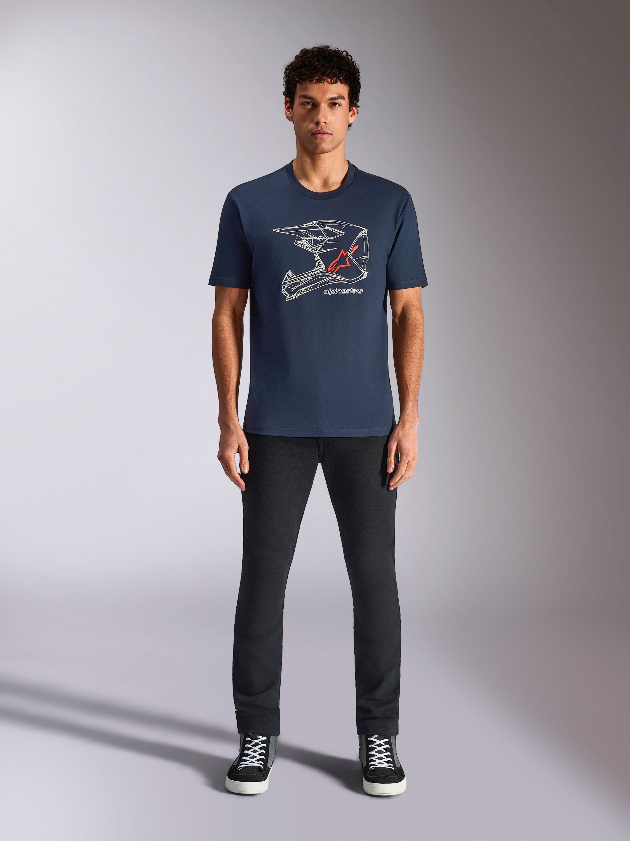 Alpinestars MX Helmet CSF Tee, Short Sleeve T-Shirt, Navy Blue, featuring White Motocross Helmet Graphic with Red Star Logo, worn by model with black pants and sneakers, casual motorsport-inspired streetwear