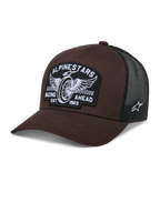 Alpinestars Heritage Patch Trucker Hat, Brown and Black, featuring a large front patch with winged wheel embroidery and 'RACING AHEAD EST. 1963' text, breathable black mesh back, curved brim, white side star logo, motorsport-inspired casual headwear
