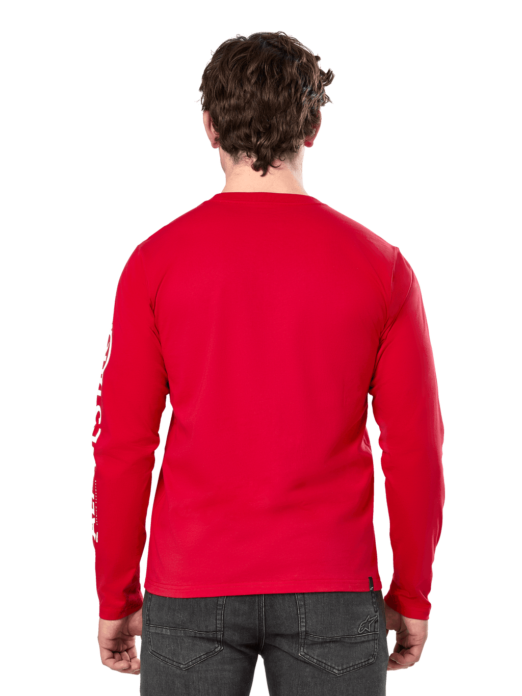 Rear view of a man wearing the Alpinestars Committed CSF Long Sleeve Tee in Red, paired with dark grey jeans, featuring a visible Alpinestars sleeve logo in white and a minimalist back design.