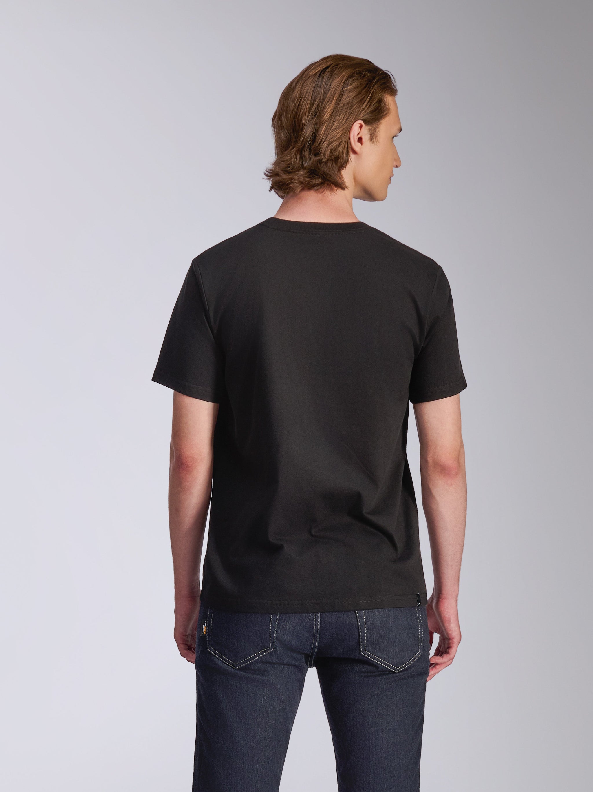 Alpinestars Luxo CSF Tee, Short Sleeve T-Shirt, Black, back view, worn by a model with dark blue jeans, casual motorsport-inspired streetwear
