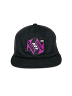 Alpinestars That Way Trucker Hat, Black Trucker Cap, features a purple and black graphic patch with "One Vision One Goal" text, flat bill, structured crown, and mesh back panels, casual motorsport-inspired headwear