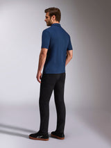 Alpinestars Impetus Sport Polo, Navy Blue Short Sleeve Polo Shirt, Back and side view on model, paired with black pants and black sneakers, casual motorsport lifestyle sportswear