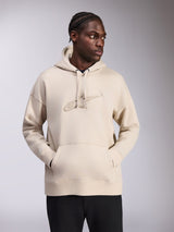 Alpinestars Emergent Oversized Hoodie, Sand color, oversized fit pullover with tonal 3D embroidered Astars logo on chest, kangaroo pocket, drawstring hood, casual streetwear worn by model with black pants.