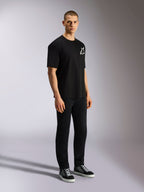 Alpinestars One Oversized CSF Tee, Short Sleeve T-Shirt, Black, white Astars logo on the chest, oversized fit, worn by a male model with black pants and sneakers, casual motorsport-inspired streetwear