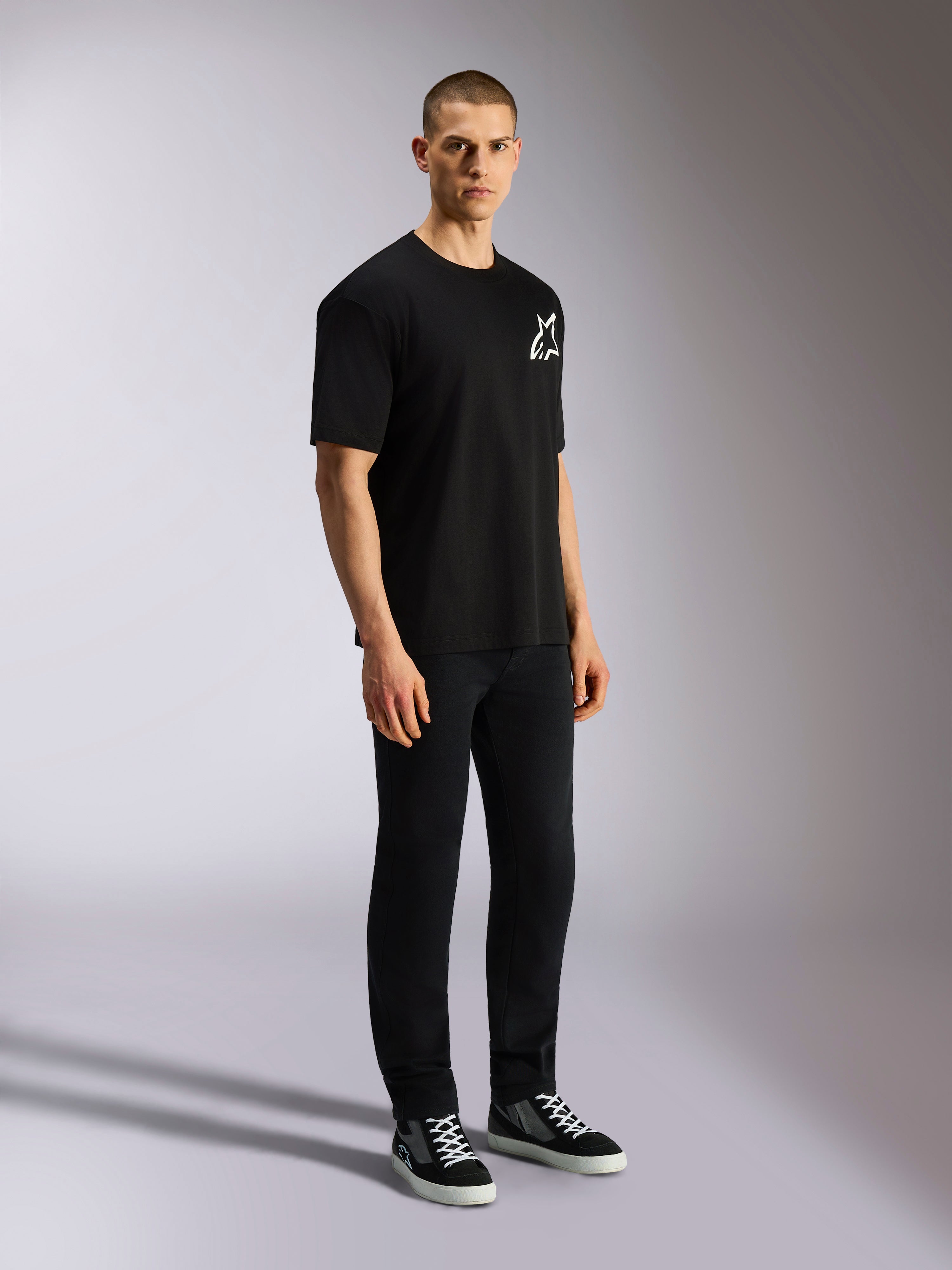 Alpinestars One Oversized CSF Tee, Short Sleeve T-Shirt, Black, white Astars logo on the chest, oversized fit, worn by a male model with black pants and sneakers, casual motorsport-inspired streetwear