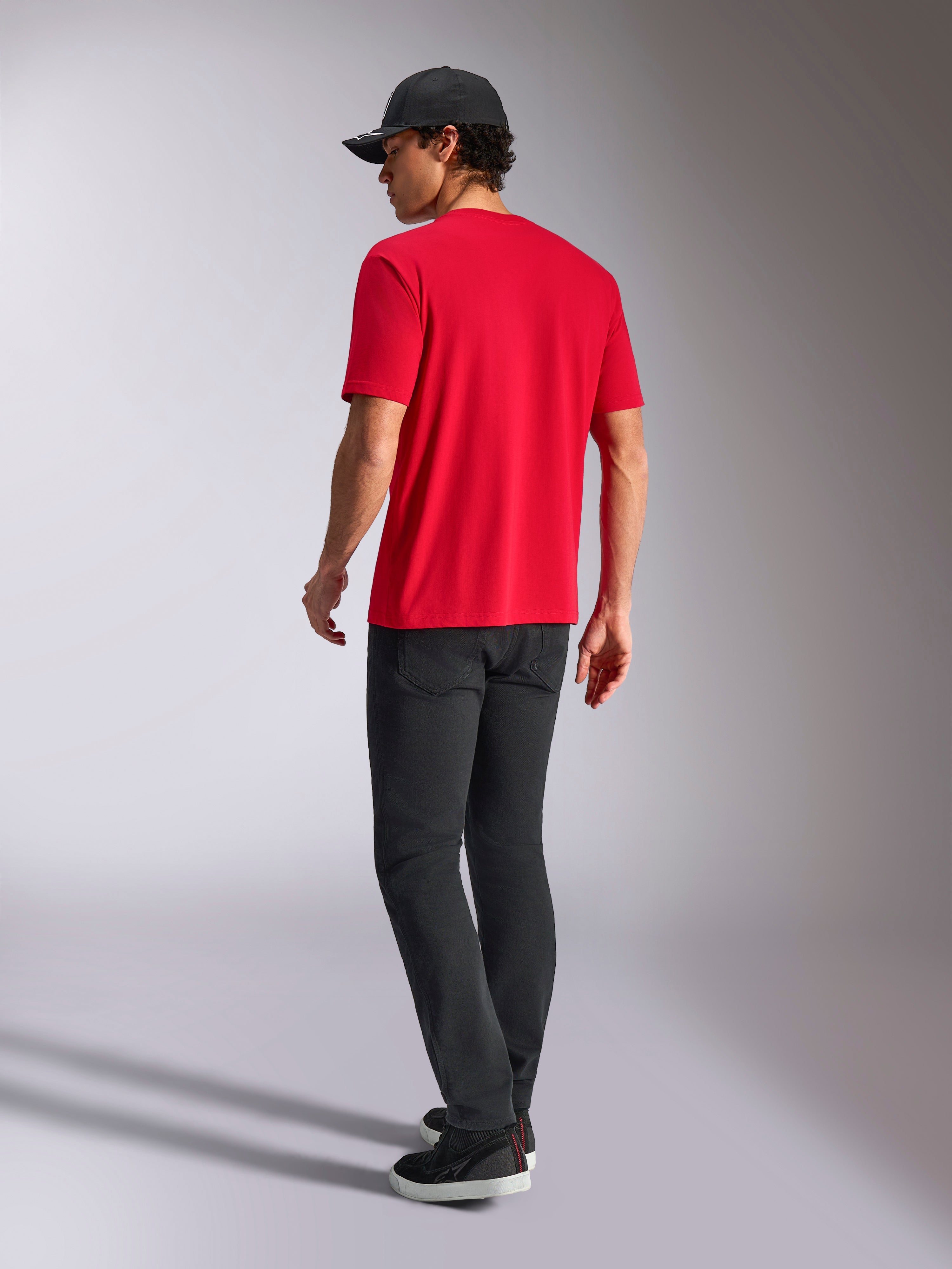 Alpinestars Noka CSF Tee, Short Sleeve T-Shirt, Red, back view, styled with black pants and a black baseball cap, casual motorsport-inspired streetwear