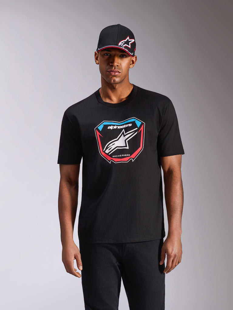 Alpinestars Plate CSF Tee, Short Sleeve T-Shirt, Black, featuring a front MX plate graphic with white logo and red and blue accents, worn by model with matching black cap, casual motorsport streetwear