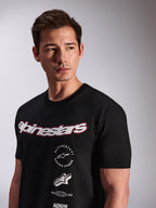 Alpinestars Abus CSF Tee, Short Sleeve T-Shirt, Black, worn by a model, featuring a white Alpinestars script logo with red outline and multi-stacked graphic logos on the chest, Casual Motorsport Streetwear