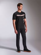 Alpinestars Abus CSF Tee, Short Sleeve T-Shirt, Black, featuring curved red and white Alpinestars logo with vertical stacked graphics, worn with black pants and sneakers, casual motorsport-inspired streetwear
