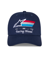 Alpinestars Trifecta Snapback Hat, Navy Blue cap with curved bill, featuring embroidered front logo with white star and tri-color stripes, 'Racing Ahead' and 'Goal One Vision' white text, structured crown, casual motorsport-inspired headwear