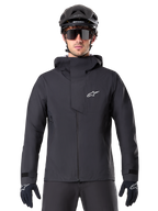 Alpinestars A-Dura Elite Waterproof Jacket, Black, Mountain Bike Jacket, High-collar design with hood, Front zipper with protective chest flap and white logo, Worn with black helmet and cycling gloves, Technical weather protection for trail riding
