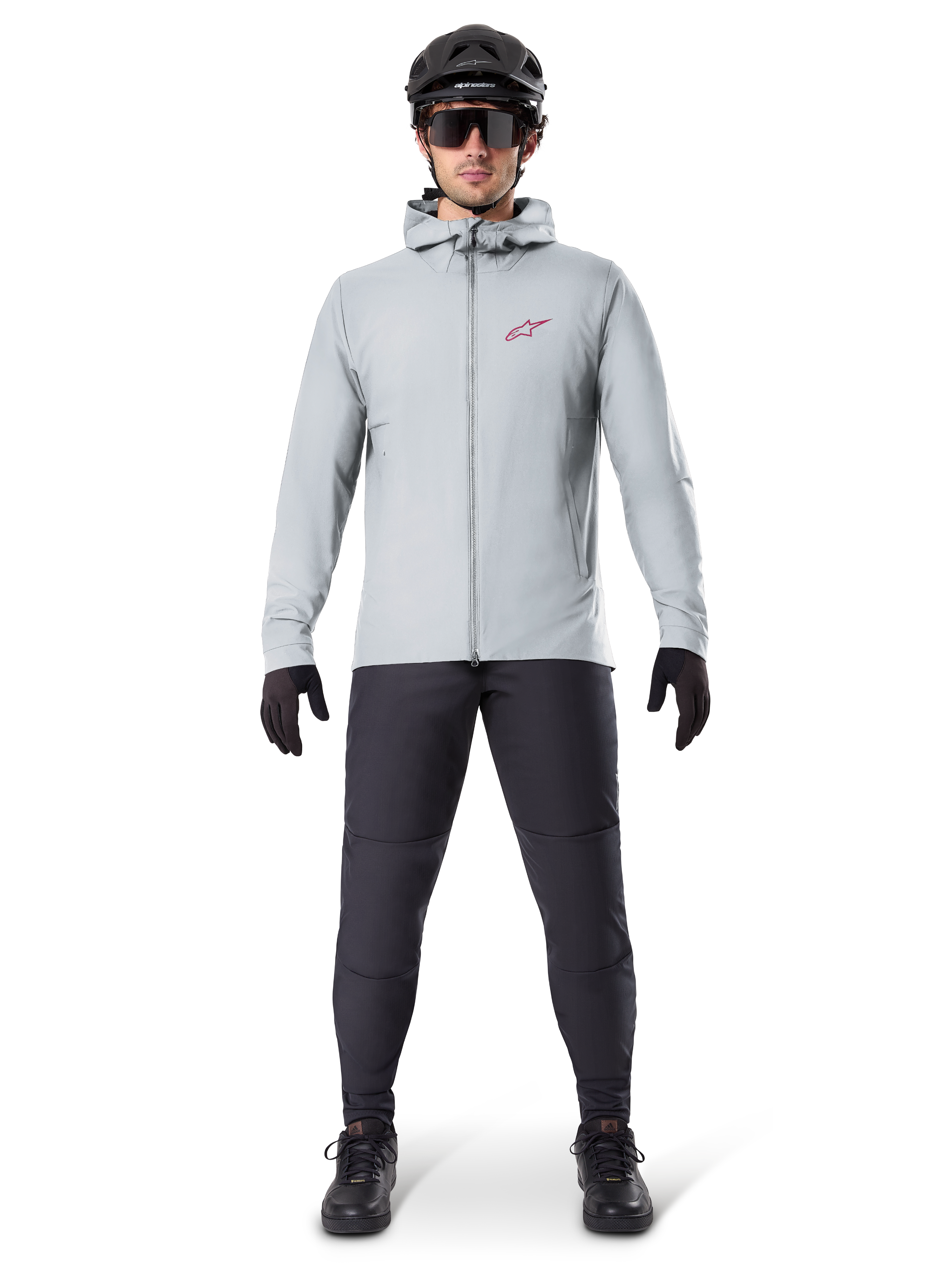 Alpinestars A-Dura Thermal Jacket, Titanium gray, cycling jacket worn with black mountain biking pants, gloves, and helmet, featuring a small red star logo on the chest and a full front zipper, lightweight insulated gear for off-road riding.