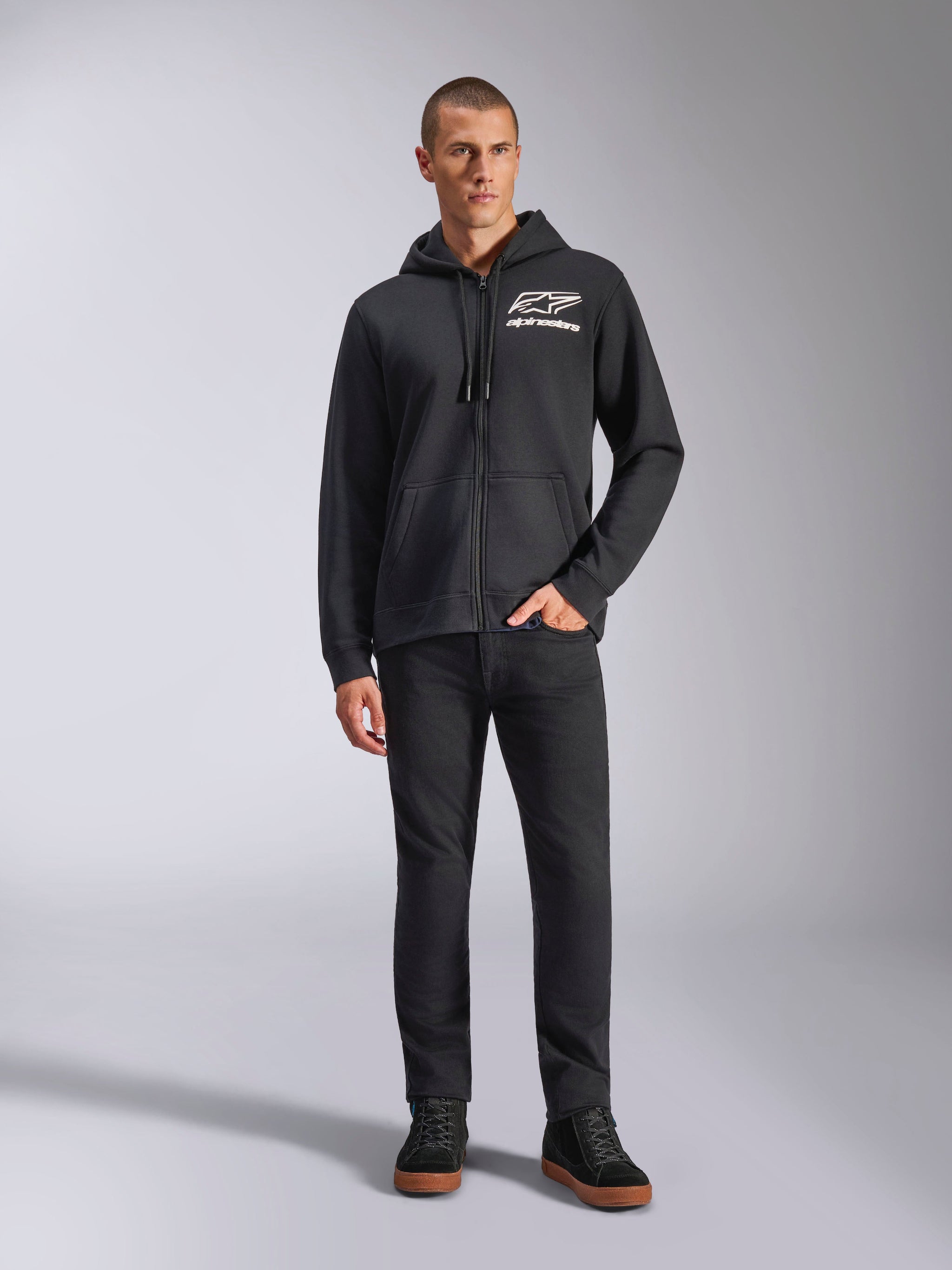 Alpinestars Formulation Hoodie, Full-Zip Hoodie, Black, White Alpinestars Logo on Chest, paired with black pants and sneakers, casual motorsport-inspired lifestyle apparel