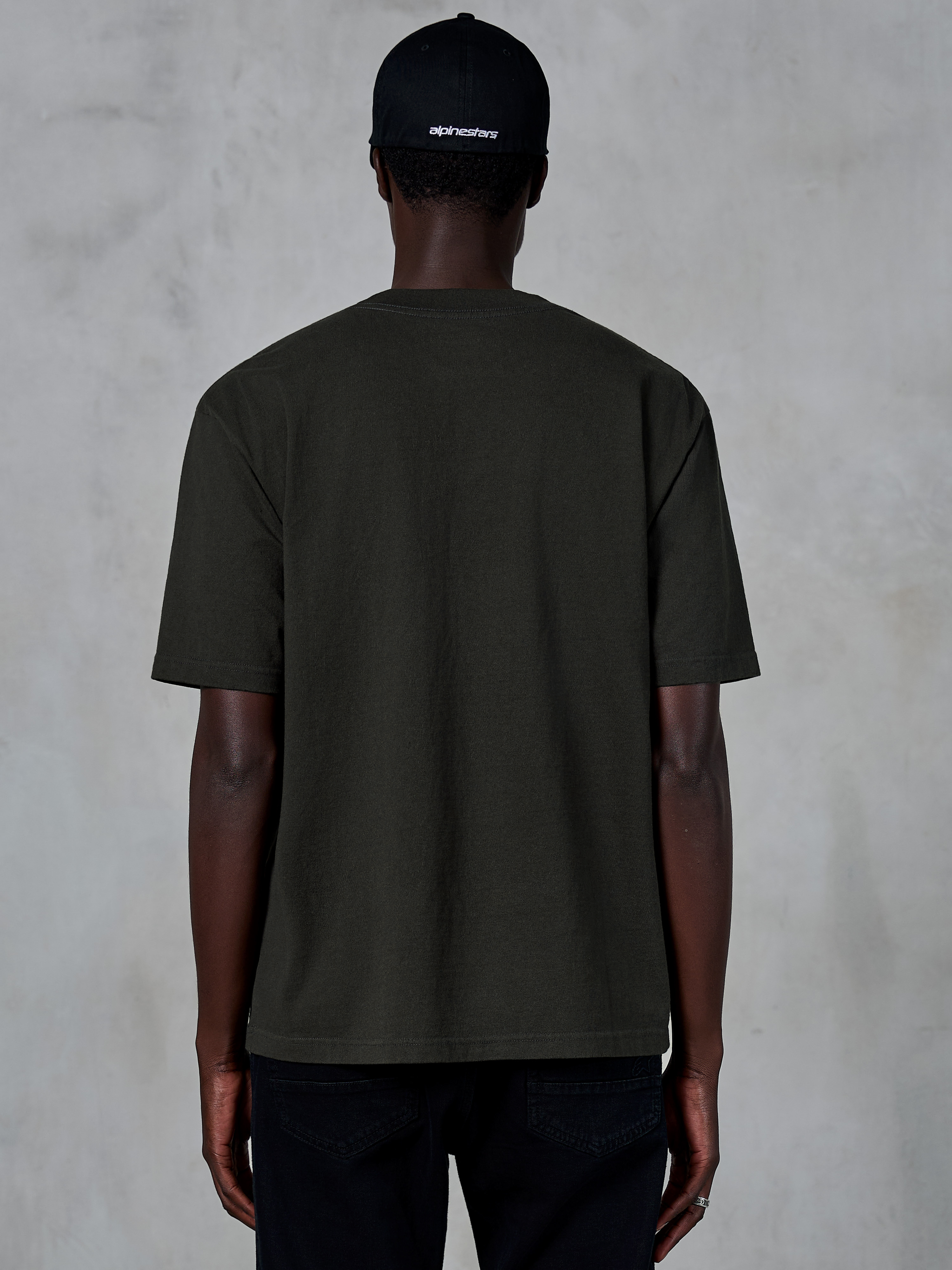 Alpinestars Essentials Ageless SS Tee, Back view of a short-sleeve T-shirt, Off Black, organic cotton jersey with a relaxed fit, casual motorsport-inspired streetwear paired with a black logo cap