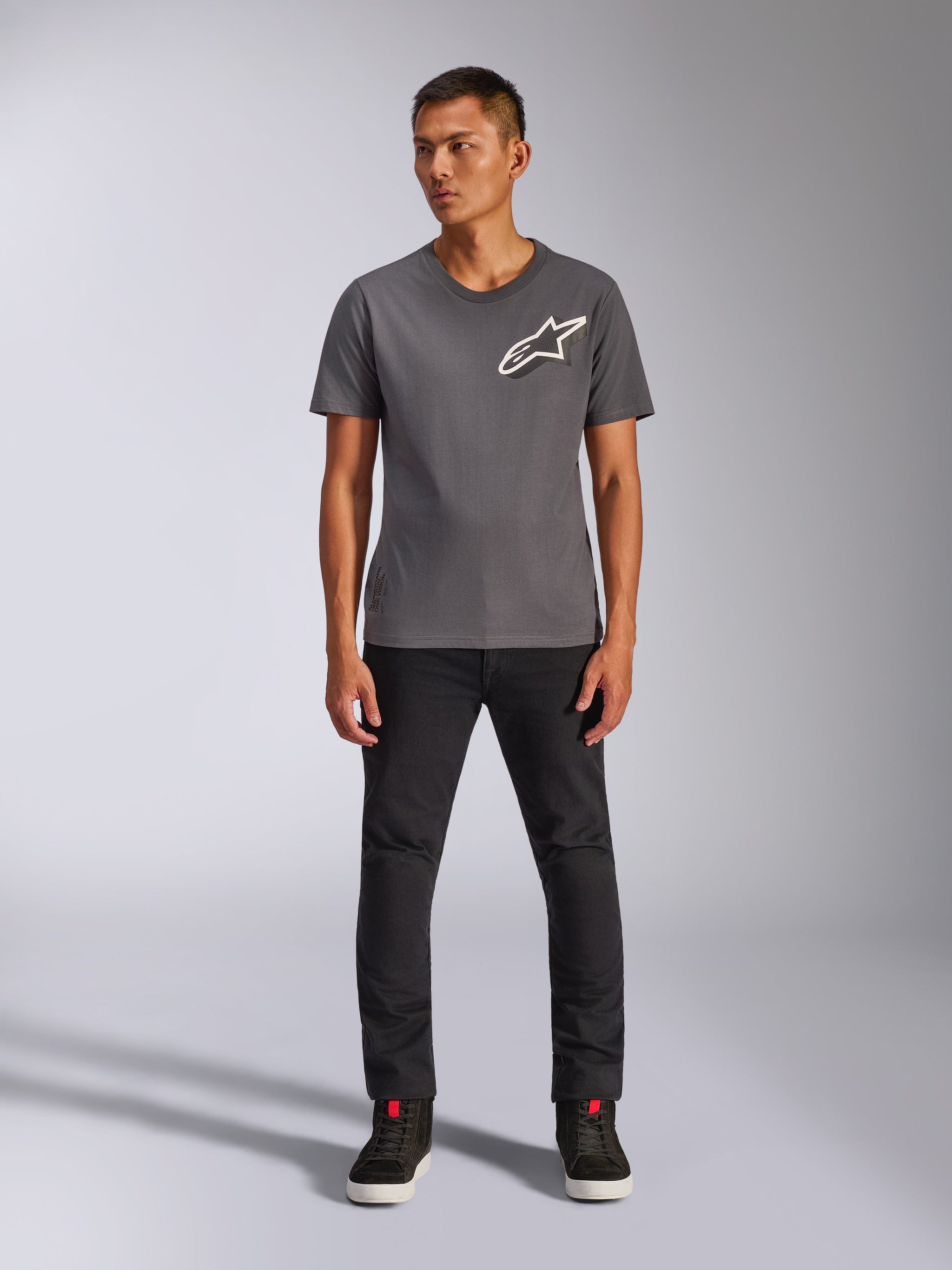Alpinestars Shaded CSF Tee, Short Sleeve T-Shirt, Charcoal, featuring a white slanted Alpinestars logo on the chest, worn by a model with black pants and black sneakers, casual motorsport streetwear