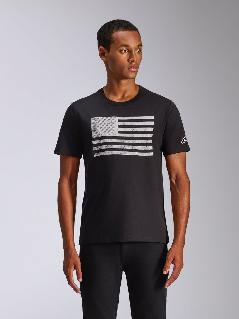 Alpinestars Waving CSF Tee, Short Sleeve T-Shirt, Black, Distressed White Flag Graphic with Integrated Logos, Small White Logo on Sleeve, worn by a model, Casual Motorsport Streetwear