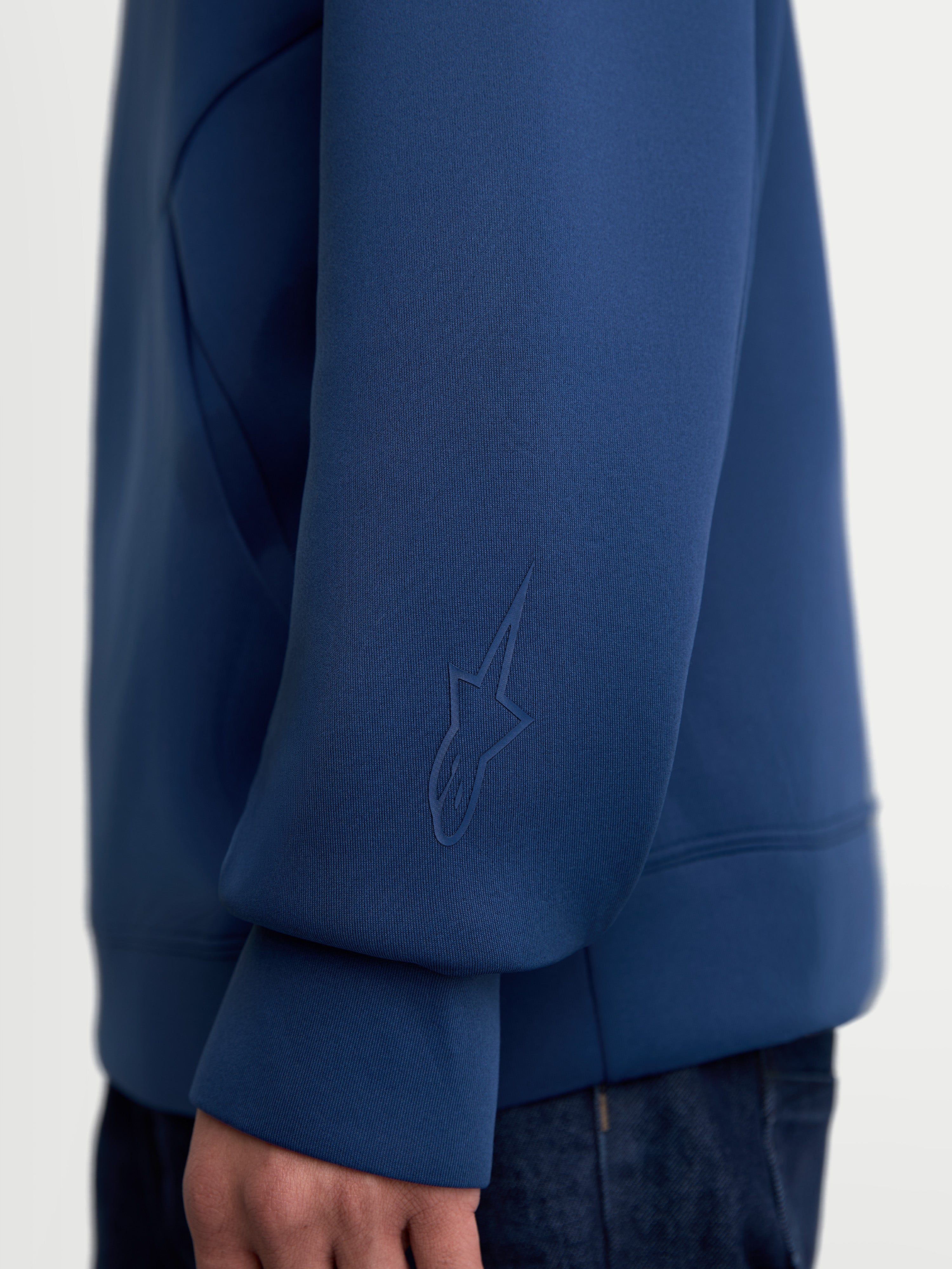 Alpinestars Datrix Hoodie, Premium Sportswear Pullover, Steel Blue, close-up view of the sleeve featuring a tonal HD Alpinestars logo, made from tri-blend double-face fleece fabric for casual everyday wear.