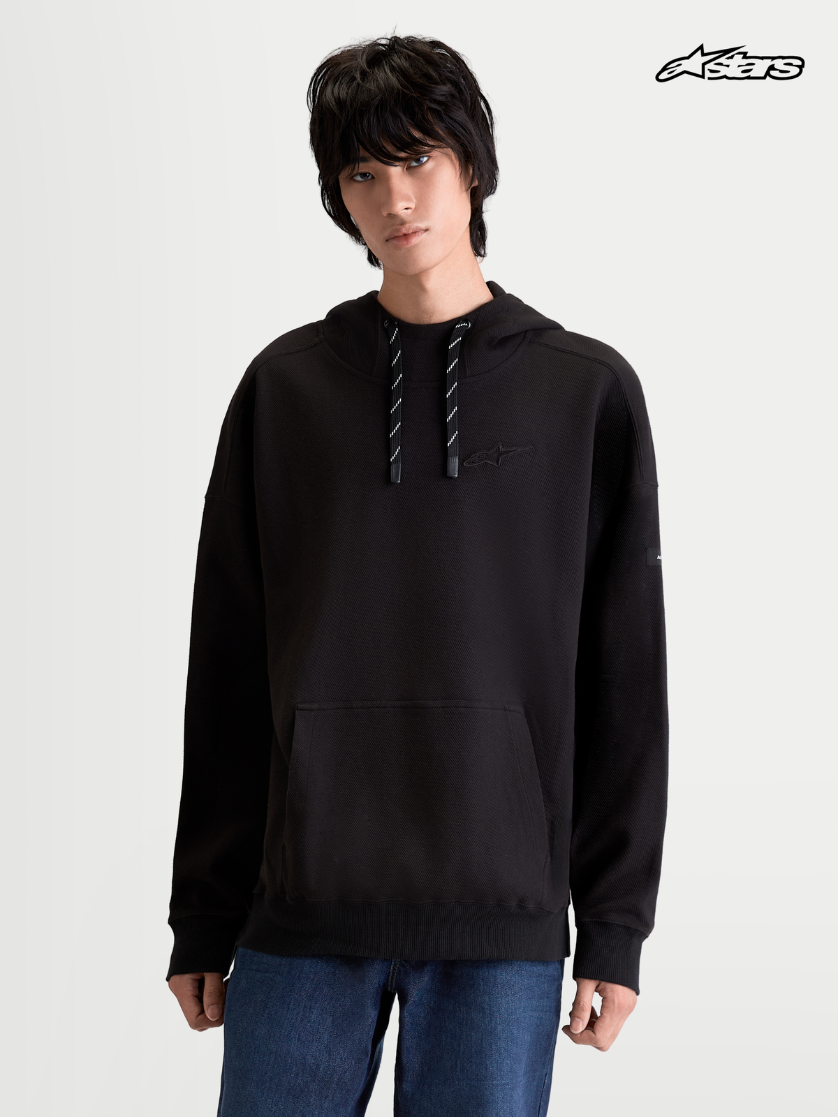 Alpinestars Camino Textured Oversized Hoodie, sportswear pullover worn by a model, black, textured knit twill fleece with kangaroo pocket and high collar