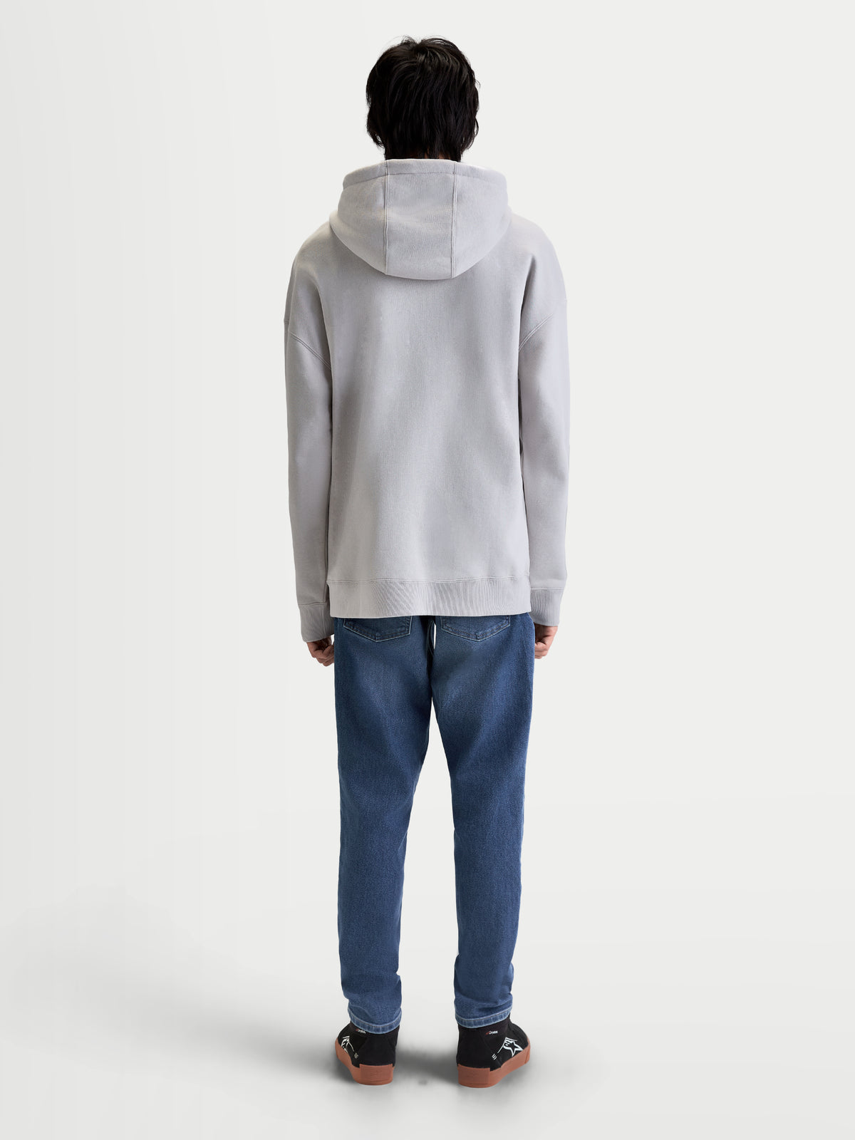 Alpinestars Prelude Oversized Hoodie, Men's Sportswear Fleece Pullover in Cement Gray, rear view on model showing the relaxed fit, self-lined hood, and ribbed cuffs and hem.