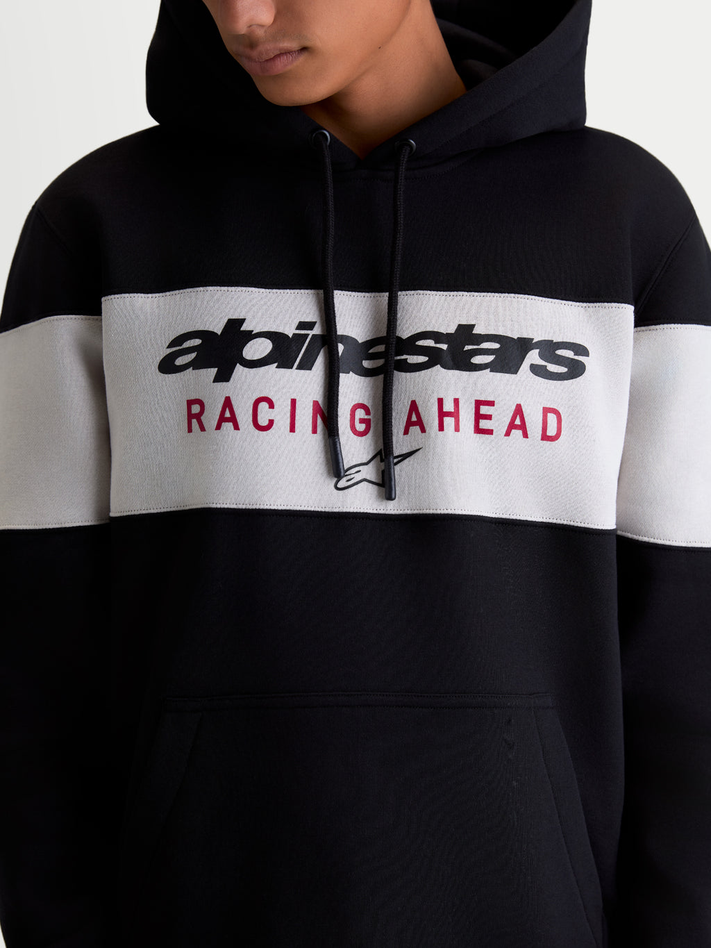 Alpinestars Cubic Hoodie, Sportswear Pullover Fleece for Men and Women, Black and Cement Grey Color-blocked Design, featuring Alpinestars Wordmark and Racing Ahead Chest Logo Graphic, On-model Detail.