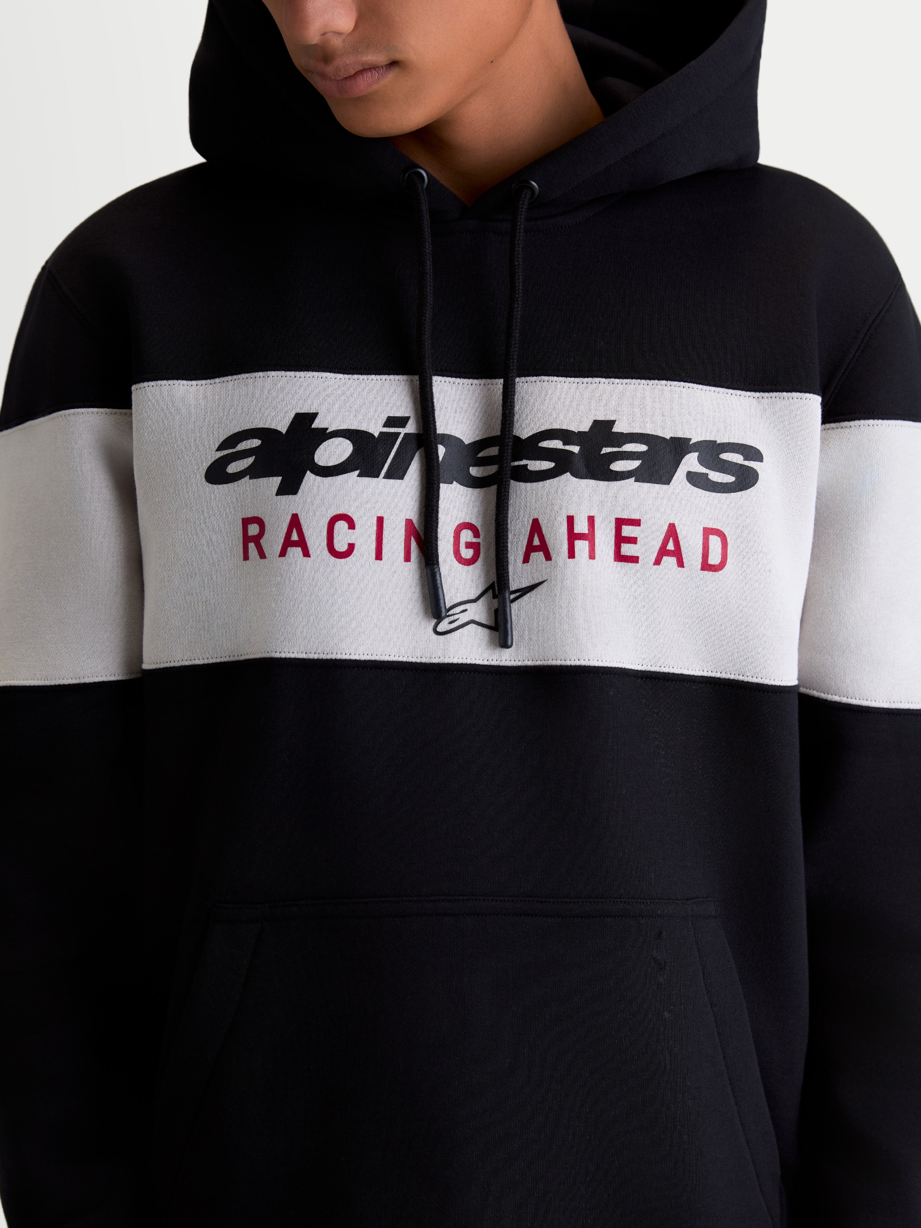 Alpinestars Cubic Hoodie, Sportswear Pullover Fleece for Men and Women, Black and Cement Grey Color-blocked Design, featuring Alpinestars Wordmark and Racing Ahead Chest Logo Graphic, On-model Detail.