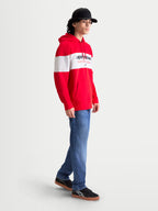 Alpinestars Cubic Hoodie, Men's Sportswear Pullover Fleece in Red and White, featuring a color-blocked design and bold Alpinestars word logo on the chest. On-model side view showing the drawstring hood, front pouch pocket, and ribbed cuffs for casual off-bike comfort.