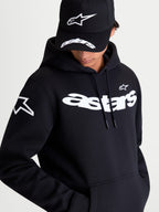 Alpinestars Velocifier Hoodie, Black Sportswear Pullover Fleece, on-model view showcasing the white curved Astars wordmark on the chest and star logo on the shoulder. This premium casual hoodie features a drawstring hood and kangaroo pocket, ideal for off-bike motorsports style.