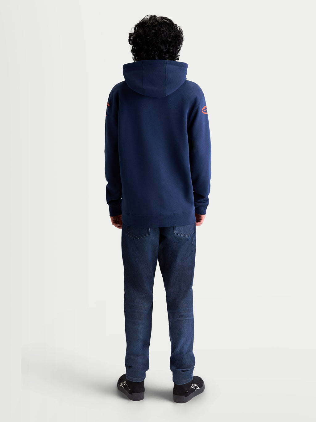 Alpinestars Velocifier Hoodie, Sportswear Pullover Fleece, Navy Blue with Red Shoulder Logos, Rear View on Model, Premium Cotton and Recycled Polyester Blend for Casual Off-Bike Style.