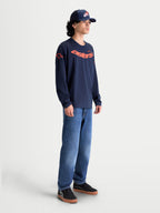 Alpinestars Velocifier CSF Tee, Men's Long Sleeve Sportswear Shirt in Navy Blue and Orange, Cotton and Recycled Polyester blend with curved Astars graphic and shoulder logos, modeled for casual lifestyle wear.