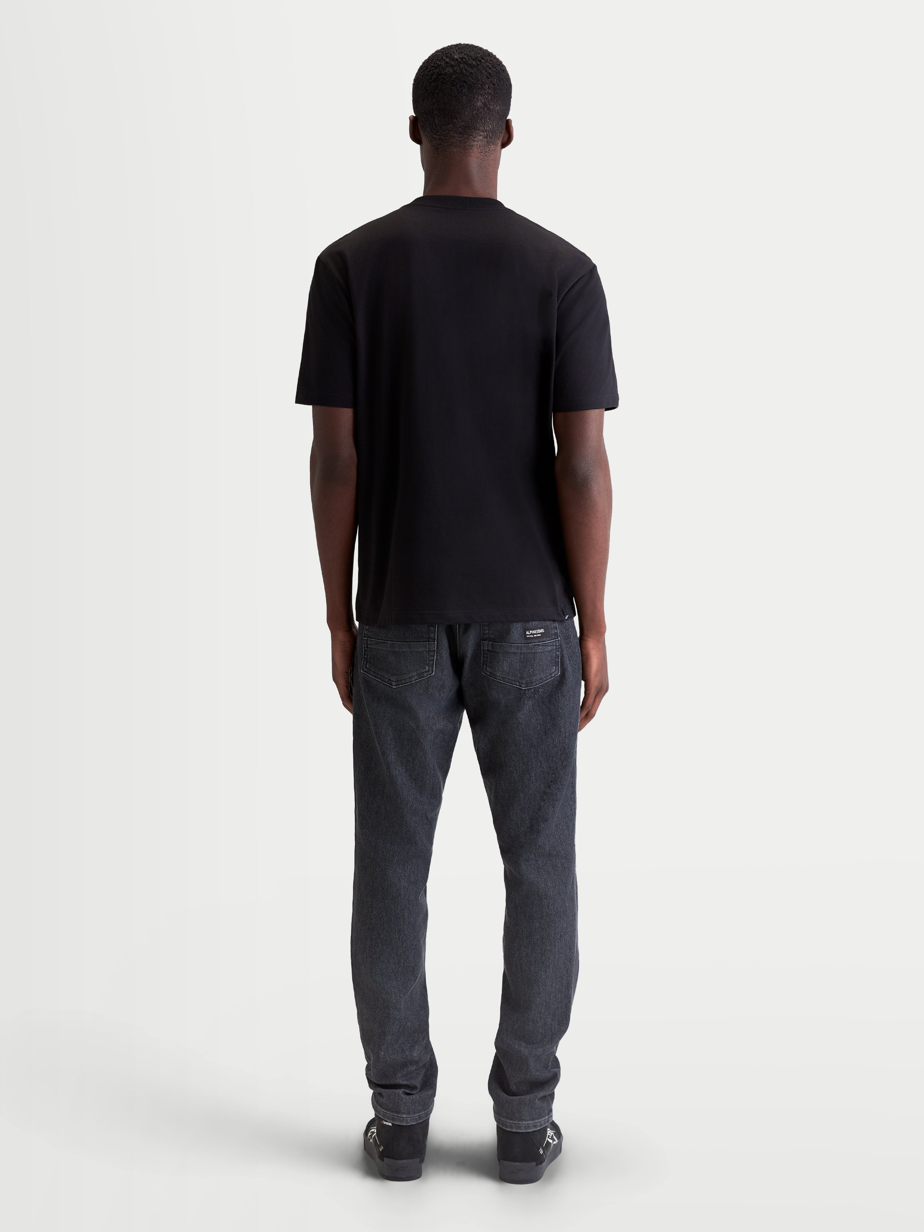 Alpinestars Singular CSF Tee, Short Sleeve Sportswear T-shirt for Men and Women, Black, Back View on Model, Premium Cotton Blend Material for Casual Everyday Wear.