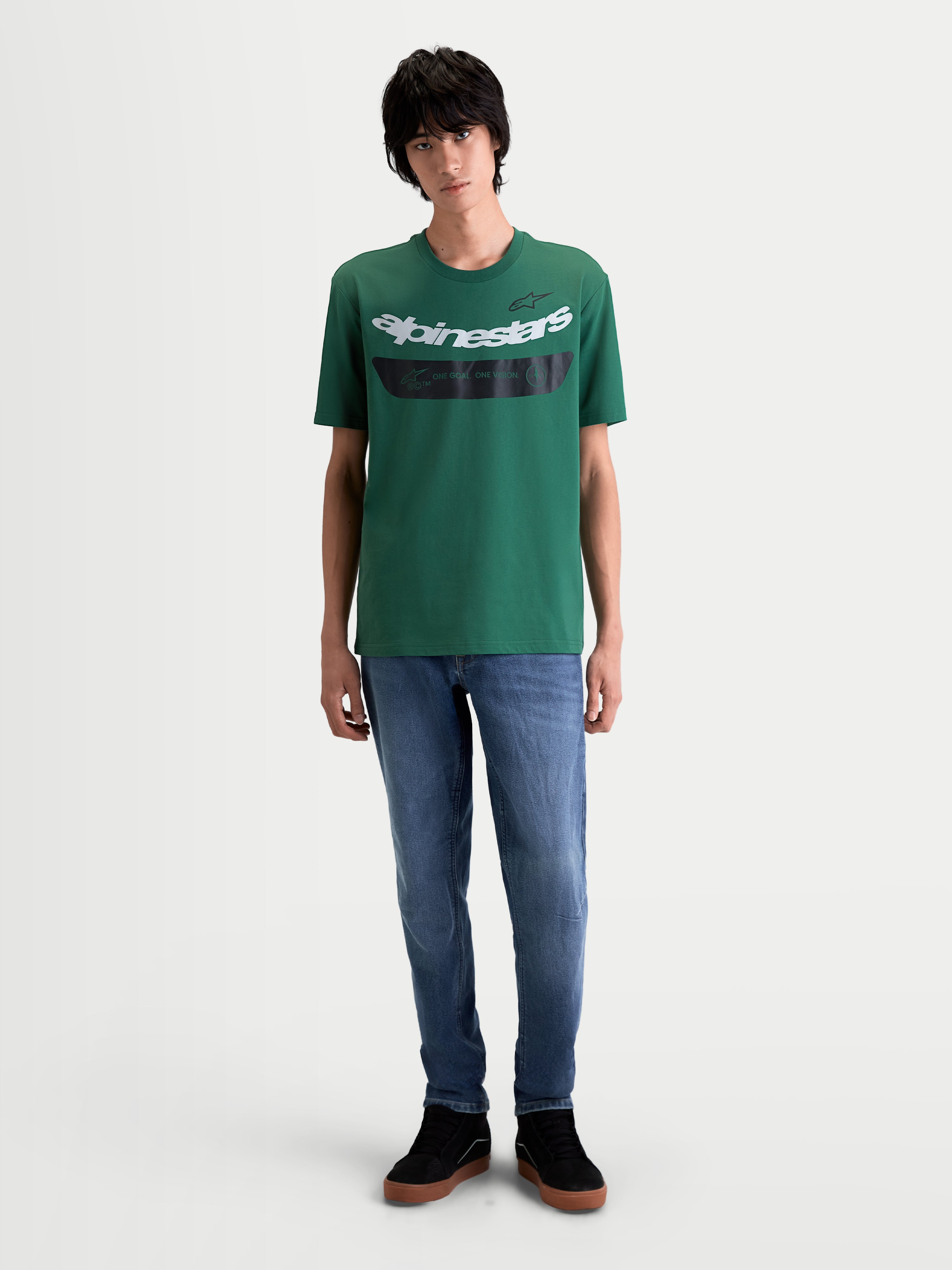Alpinestars Singular CSF Tee, casual short-sleeve sportswear t-shirt, green with a white curved Astars word graphic and black chest detail featuring 'One Goal. One Vision.' text, on-model front view, 60/40 cotton-poly blend.