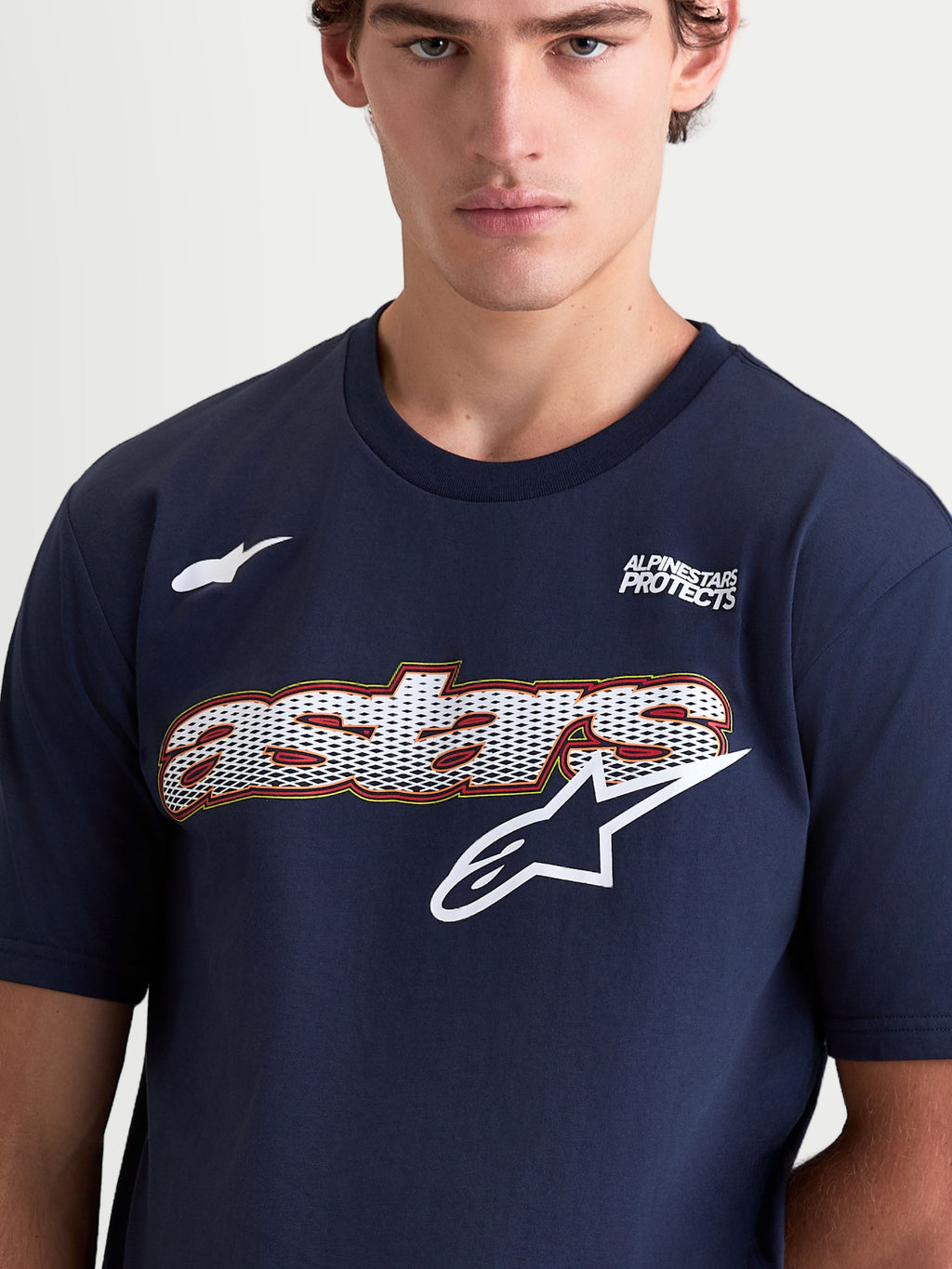 Alpinestars Cypress CSF Tee, Short-Sleeve Sportswear T-Shirt, Navy Blue, featuring a front Astars word mesh-fill graphic with star logo and Alpinestars Protects text. On-model close-up highlighting the soft cotton-poly material and lifestyle design.