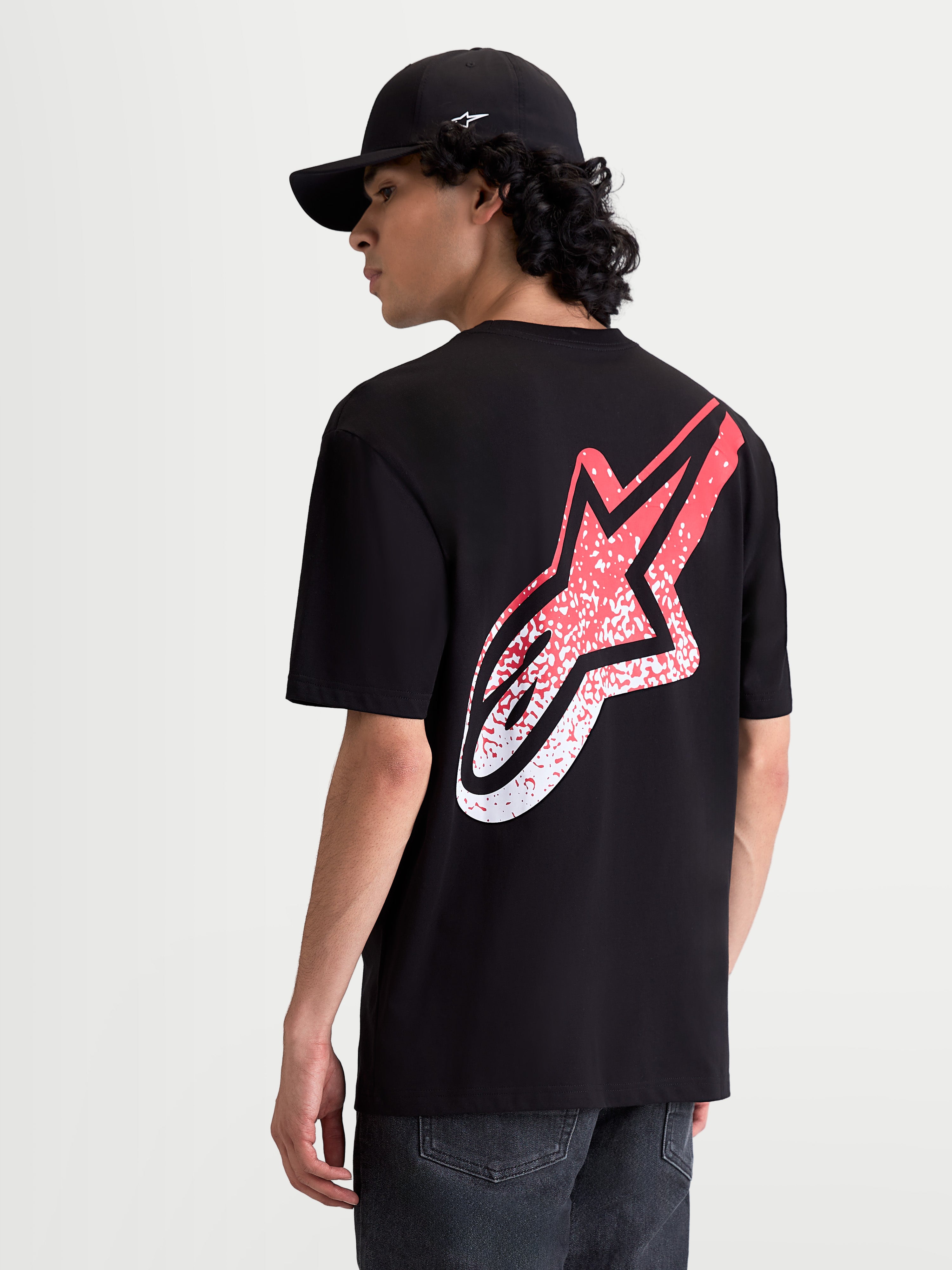 Alpinestars Meteor CSF Tee, Men's Short Sleeve Sportswear T-Shirt, Black and Red, featuring a large MX-inspired gradient Astars logo on the back, on-model rear view, soft cotton-poly blend for casual everyday comfort.