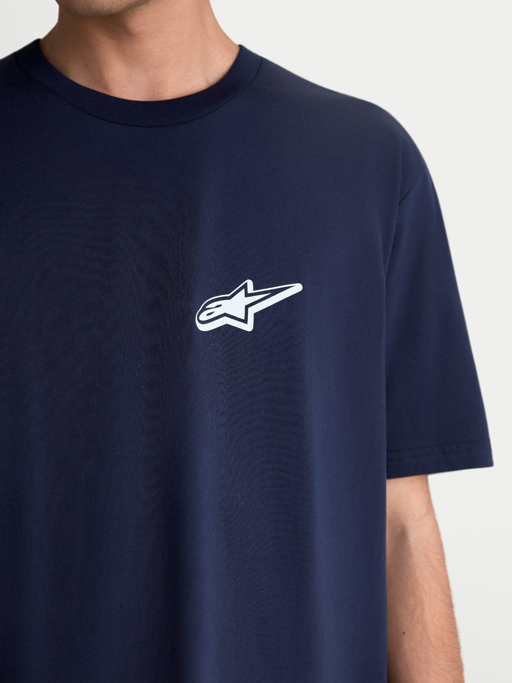 Alpinestars Meteor CSF Tee, Short Sleeve Sportswear T-shirt, Navy Blue with a white Astars chest logo, unisex casual motorsport apparel, soft cotton-poly blend fabric, close-up view on model.