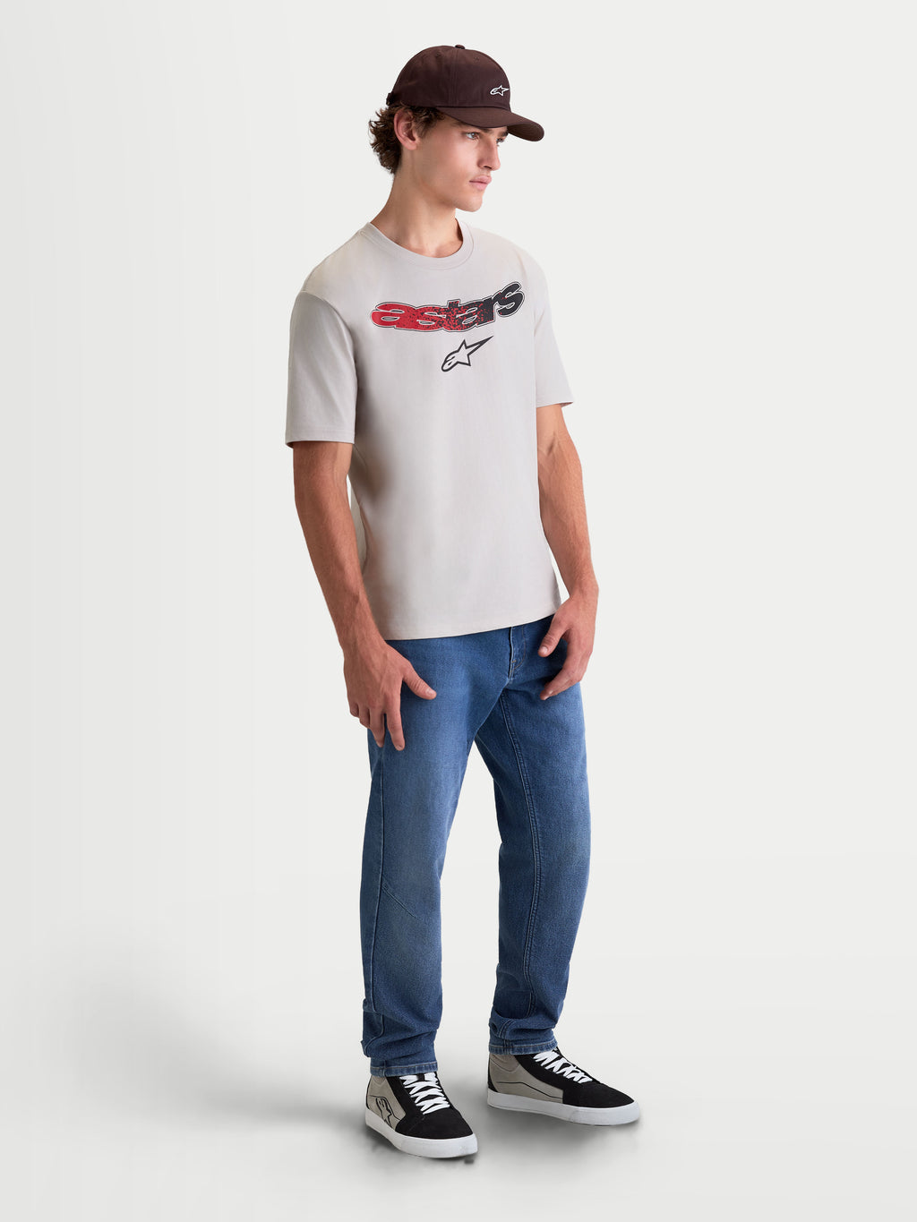Alpinestars Elliptogrit CSF Tee, Short Sleeve Sportswear T-Shirt, Cement Gray, featuring a curved Astars wordmark with red and black gradient detailing and soft-hand print, on-model full-body shot for a casual motorsport-inspired lifestyle look.