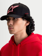 Alpinestars Lineout Hat, Black Curved Bill Sportswear Baseball Cap, featuring a structured crown with red and white embroidered Astars logo and side branding, shown on a model.