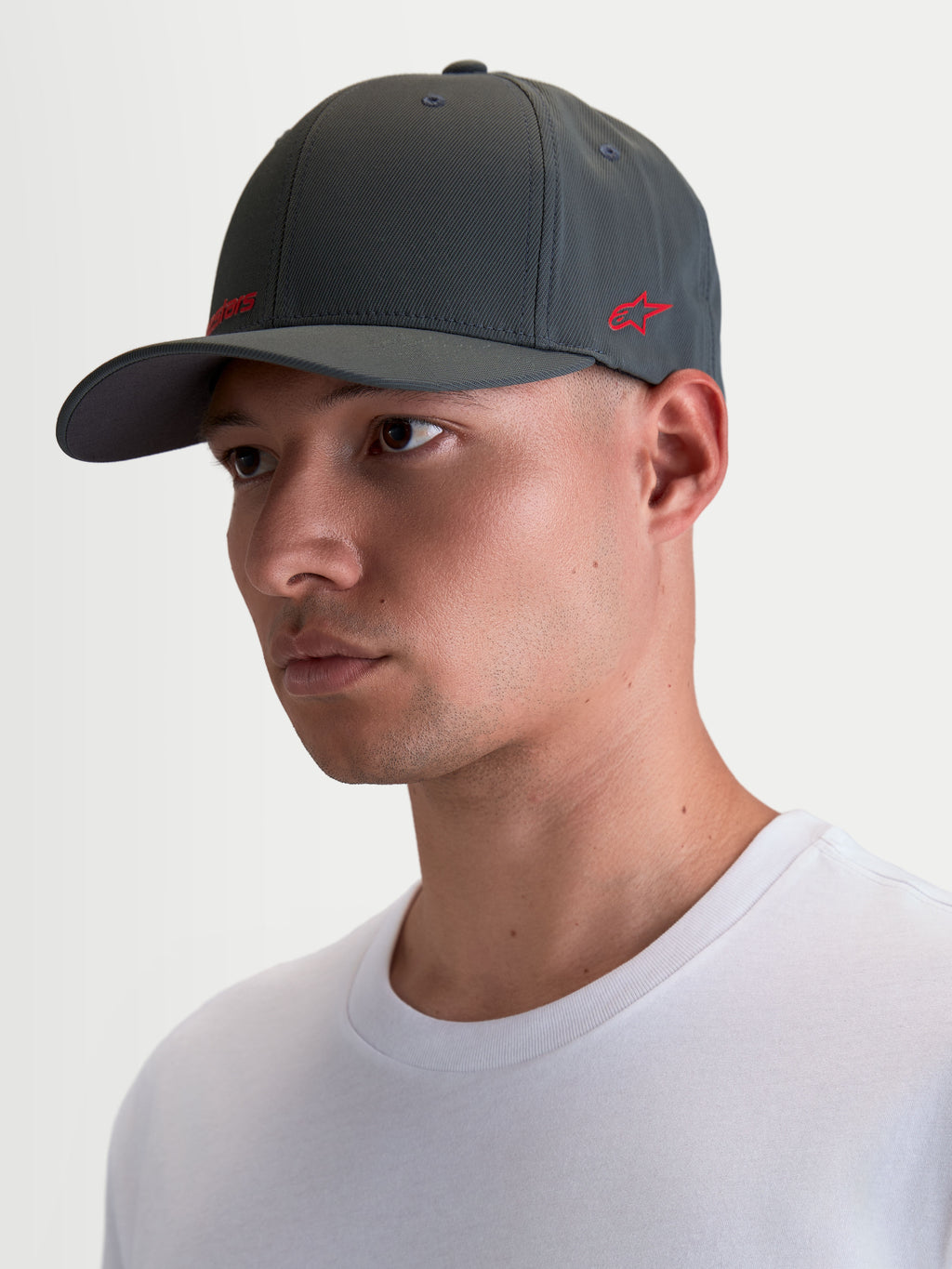 Alpinestars Points Hat, Sportswear Curved Bill Cap on Model, Dark Grey with Red Logo, Lightweight Nylon Tactel, Flex-back Fit for Everyday Comfort.