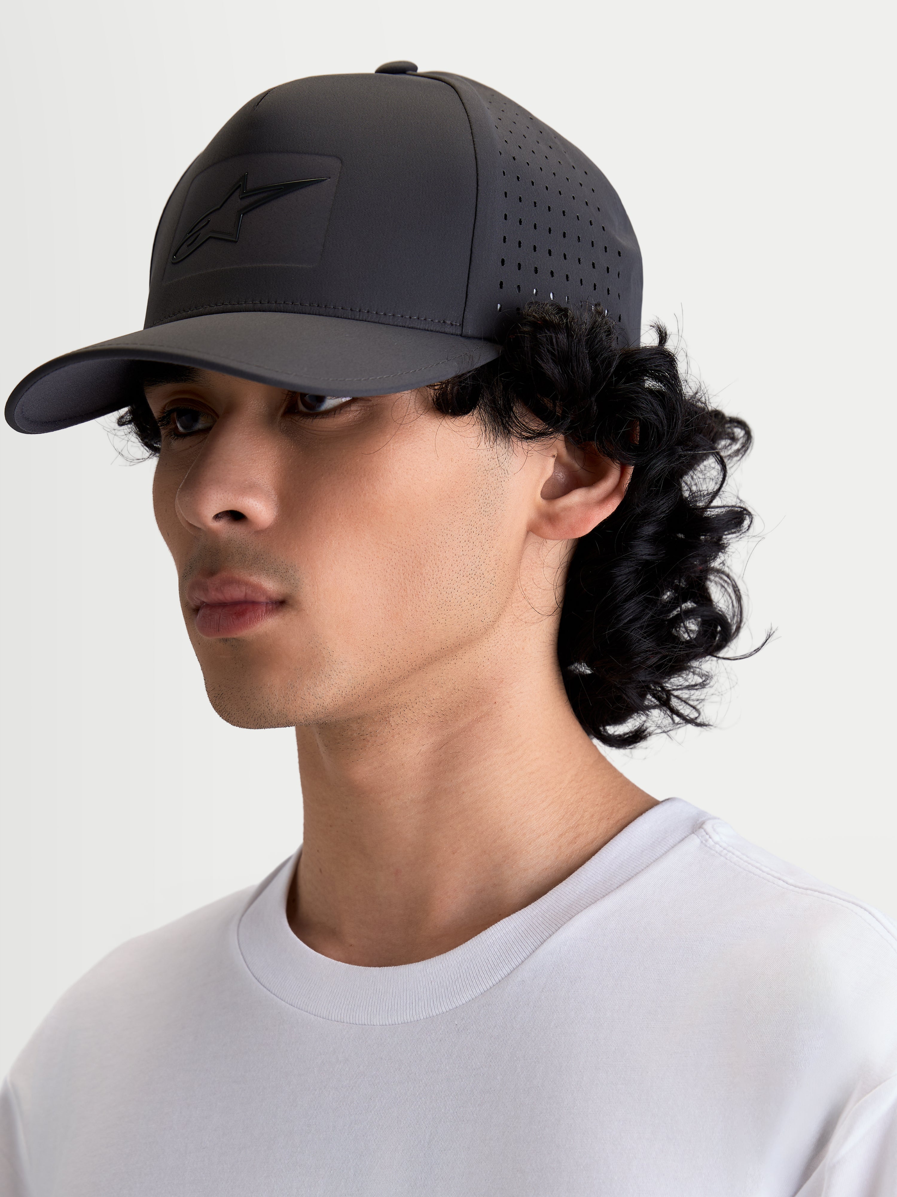 Alpinestars Algo Perf Adjustable Hat, Sportswear Snapback in Dark Grey, on-model side view showing side perforations for airflow, technical fabric construction, sonic-weld logo, and curved bill.